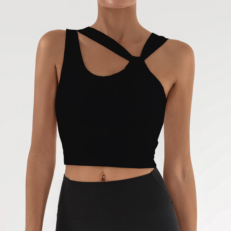 Frau in schwarzem, ärmellosem Sporttop mit überkreuztem Design, ideal für Fitness und Yoga. Modernes, stilvolles Sportbekleidungs-Outfit.