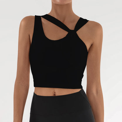 Frau in schwarzem, ärmellosem Sporttop mit überkreuztem Design, ideal für Fitness und Yoga. Modernes, stilvolles Sportbekleidungs-Outfit.