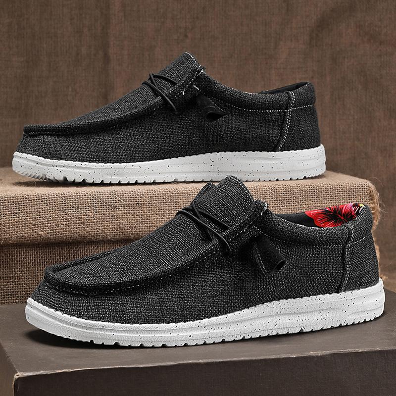 Schwarze Herren-Slipper aus Leinen mit weißer Sohle, lässiges Design, ideal für Freizeit und Alltag, komfortabel und stilvoll.