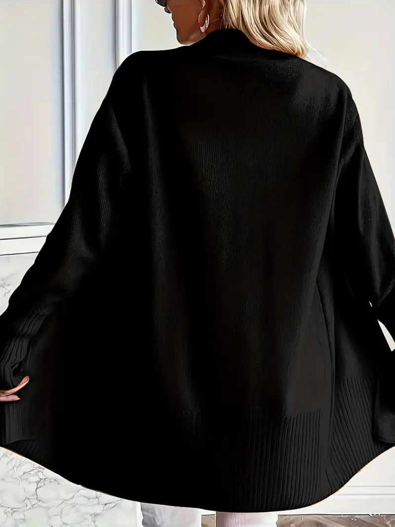 Frau trägt langen schwarzen Cardigan, Rückansicht. Modetrend, Damenmode, Herbstbekleidung, eleganter Strick, stilvoller Look.