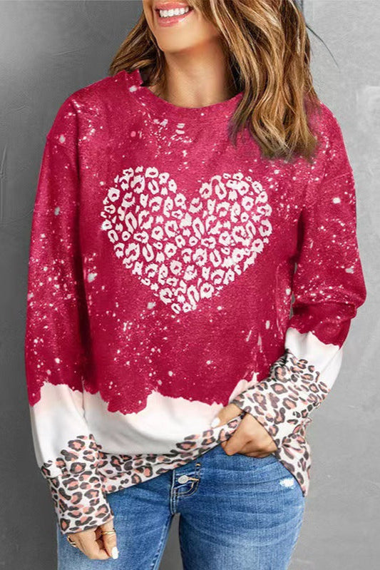 Frau trägt roten Pullover mit Herzmuster und Leopardenprint, kombiniert mit blauer Jeans. Modetrend, lässiger Stil, Damenmode.