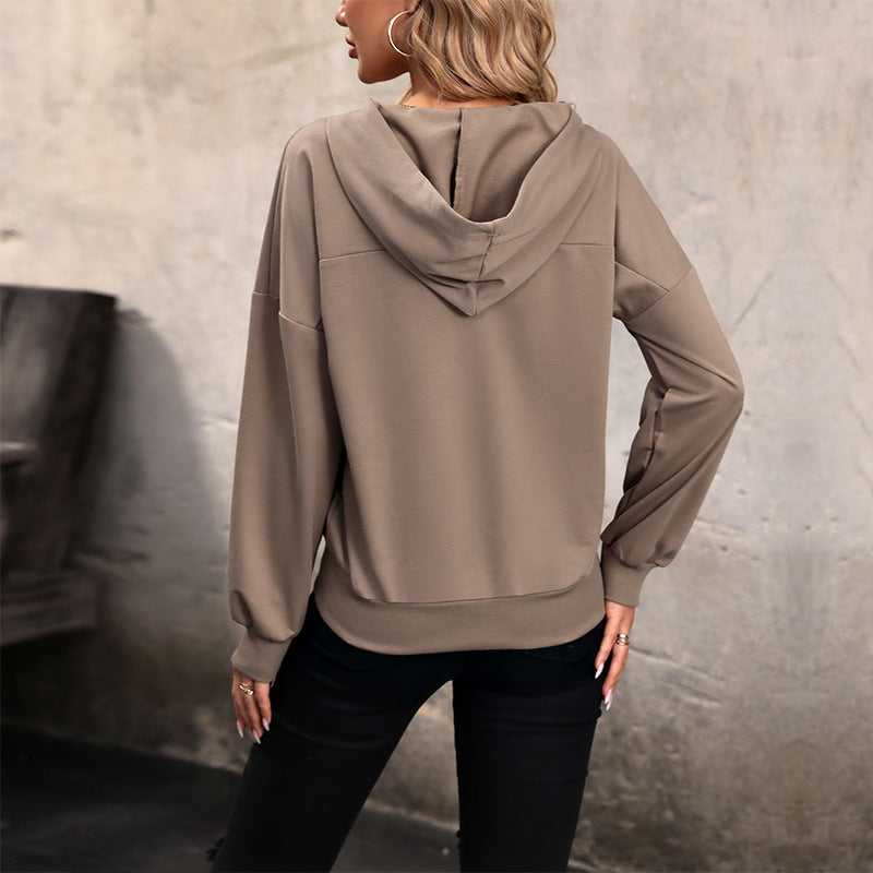 Frau in beigem Hoodie von hinten, lässiger Stil, urbaner Hintergrund, modische Freizeitkleidung, Herbstmode, Kapuzenpullover, Damenbekleidung.
