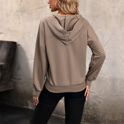 Frau in beigem Hoodie von hinten, lässiger Stil, urbaner Hintergrund, modische Freizeitkleidung, Herbstmode, Kapuzenpullover, Damenbekleidung.