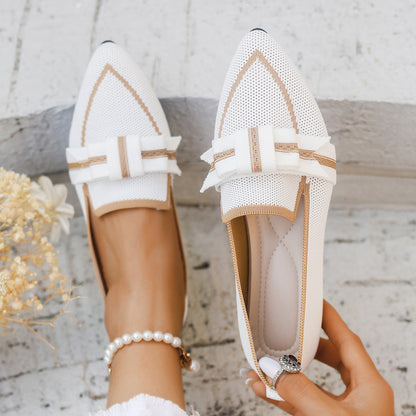 Weiße Damen-Loafer mit Schleife und Perlenarmband auf hellem Hintergrund. Modische Sommerschuhe, elegantes Design, ideal für Freizeit und Büro.