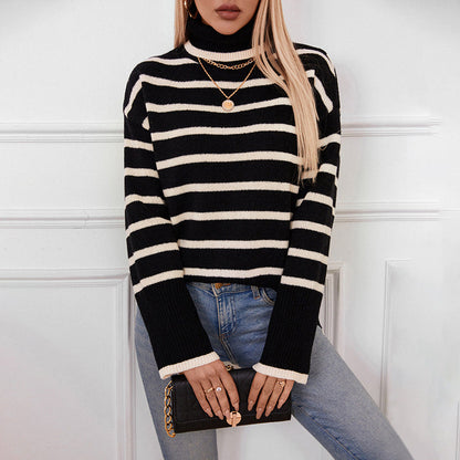 Frau in gestreiftem Rollkragenpullover, blauer Jeans, hält schwarze Clutch. Modetrend, eleganter Look, Herbstmode, Damenbekleidung.