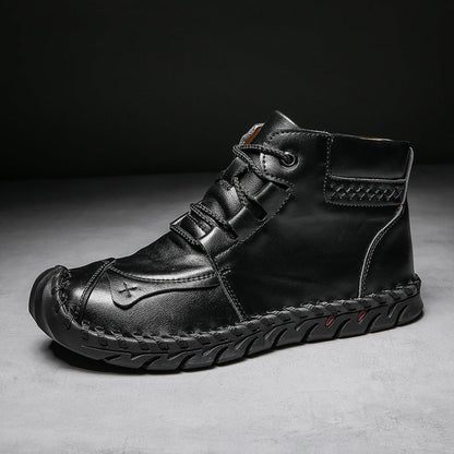 Schwarzer Herren-Lederstiefel mit Schnürung, robustem Design und genähter Sohle auf grauem Hintergrund. Bequeme, modische Herrenschuhe.