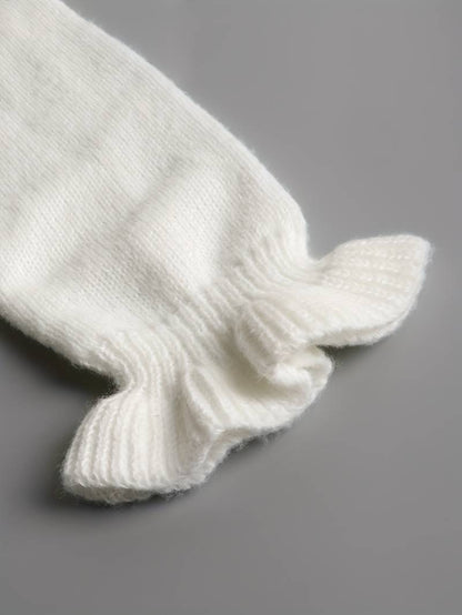 Weiße gestrickte Wollsocke auf grauem Hintergrund, weiches Material, warme Winterbekleidung, gemütliche Strickmode, Detailansicht.