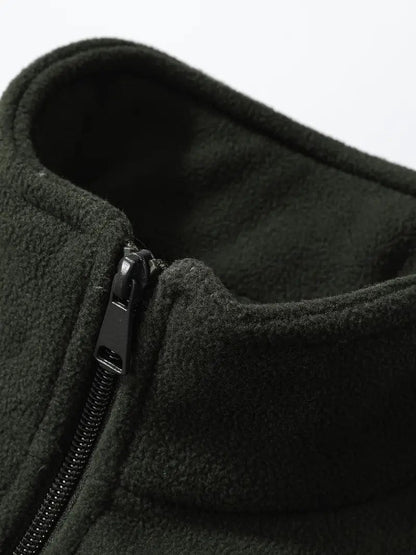 Dunkelgrüne Fleecejacke mit Reißverschluss, Nahaufnahme des Kragens. Weiches, warmes Material, ideal für Outdoor-Aktivitäten im Herbst und Winter.
