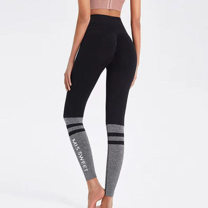 Frau in schwarzer Leggings mit grauen Streifen und "MISS SWEET" Aufdruck, Rückansicht. Sportbekleidung, Fitnessmode, bequeme Leggings.