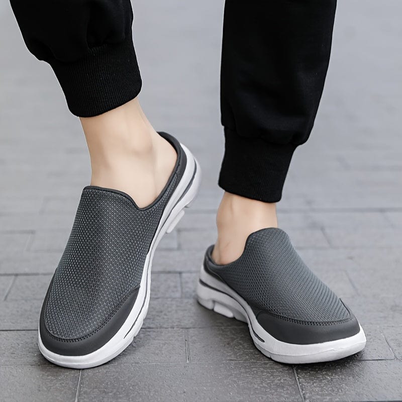 Graue Herren-Sneaker-Slipper auf Gehweg, bequemes Design, atmungsaktives Material, ideal für Freizeit und Alltag, modische Herrenschuhe.