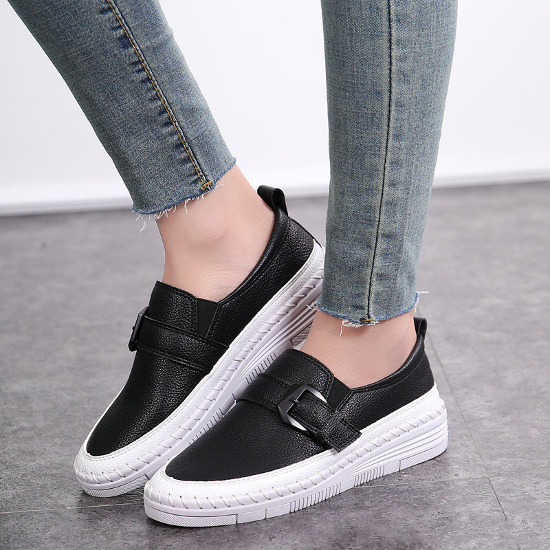 Schwarze Damen-Sneaker mit weißer Sohle, getragen zu hellblauen Jeans. Modische Freizeitschuhe, ideal für Alltag und Freizeit.