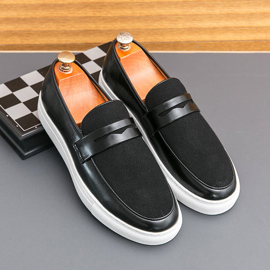 Schwarze Herren-Loafer aus Leder und Wildleder mit weißer Sohle auf grauem Hintergrund, stilvoll und modern, ideal für elegante Anlässe.