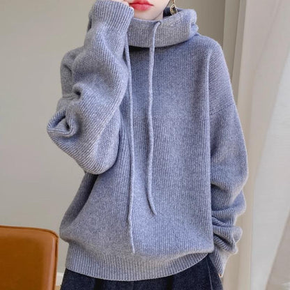 Grauer Strickpullover mit Kapuze, lässig und gemütlich, ideal für Herbstmode. Perfekt für Damen, die stilvolle und bequeme Kleidung suchen.