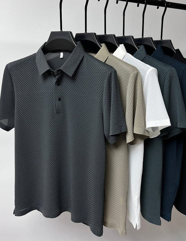 Sechs Poloshirts in verschiedenen Farben (schwarz, grau, beige, weiß, blau) auf Kleiderbügeln. Hochwertige Herrenmode, Texturdesign.