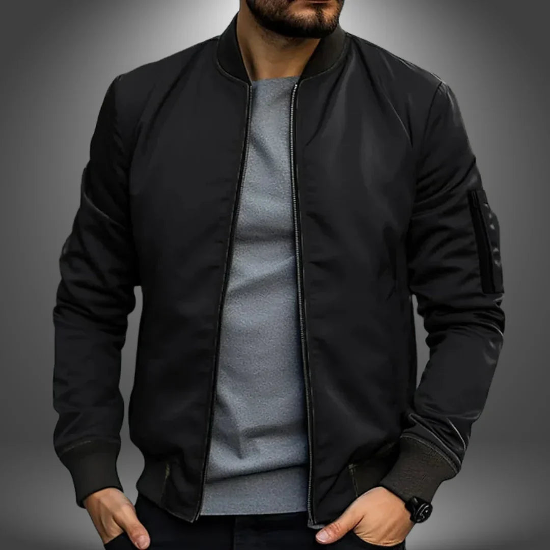 Schwarze Bomberjacke für Herren, modern und stilvoll, kombiniert mit grauem Shirt. Perfekt für lässige Outfits und urbane Mode.