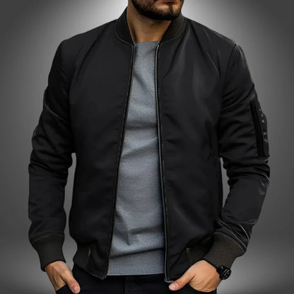 Schwarze Bomberjacke für Herren, modern und stilvoll, kombiniert mit grauem Shirt. Perfekt für lässige Outfits und urbane Mode.