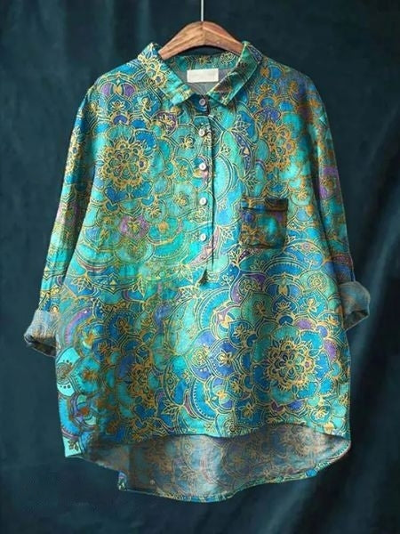 Bunte Damenbluse mit floralen Mustern, blau-goldene Farben, lockerer Schnitt, Knopfleiste, elegantes Design, ideal für modische Outfits.