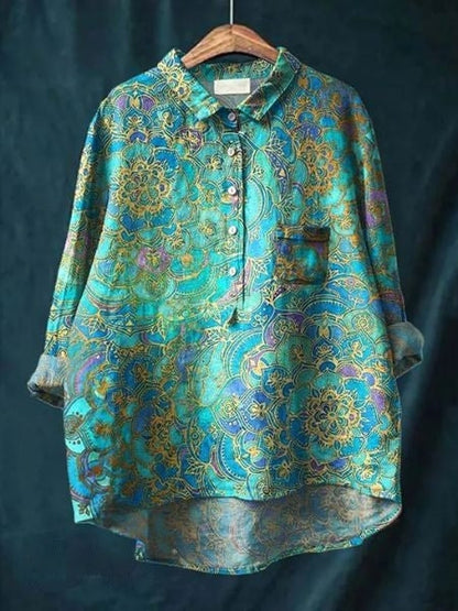 Bunte Damenbluse mit floralen Mustern, blau-goldene Farben, lockerer Schnitt, Knopfleiste, elegantes Design, ideal für modische Outfits.