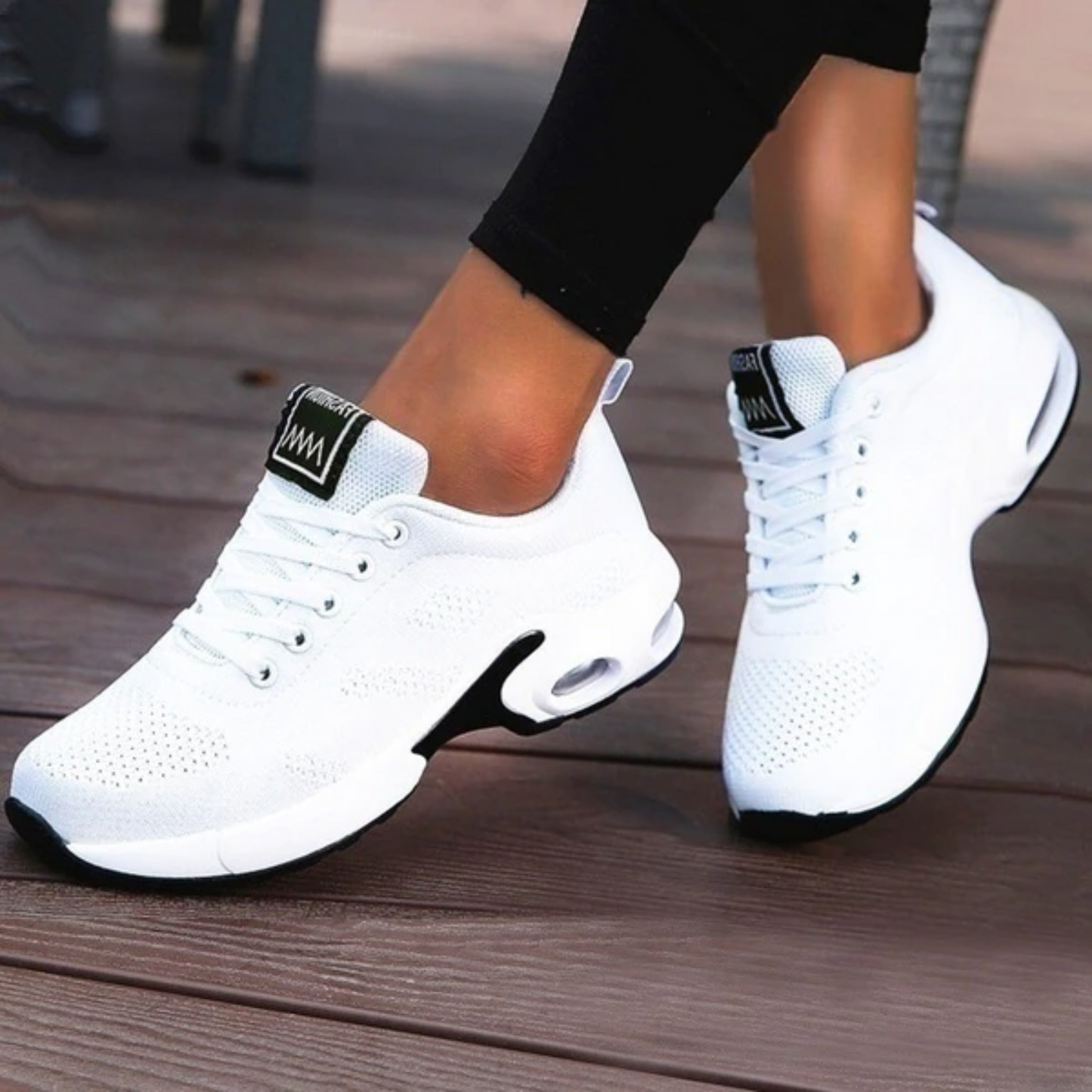 Weiße Damen-Sneaker mit Luftpolstersohle auf Holzterrasse, sportlich und modern, ideal für Fitness und Freizeit. Bequeme Sportschuhe für Damen.