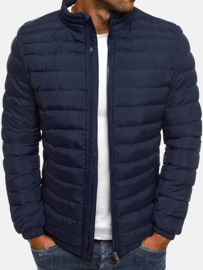 Dunkelblaue Steppjacke für Herren, modisch und warm, ideal für Herbst und Winter. Perfekt kombinierbar mit Freizeitkleidung.