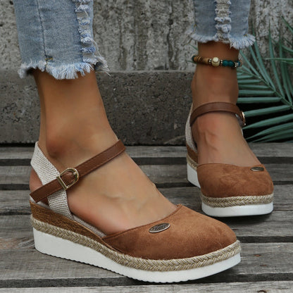 Damen-Sandalen mit Keilabsatz, braun, aus Wildleder, mit verstellbarem Riemen und geflochtener Sohle, getragen mit zerrissenen Jeans.