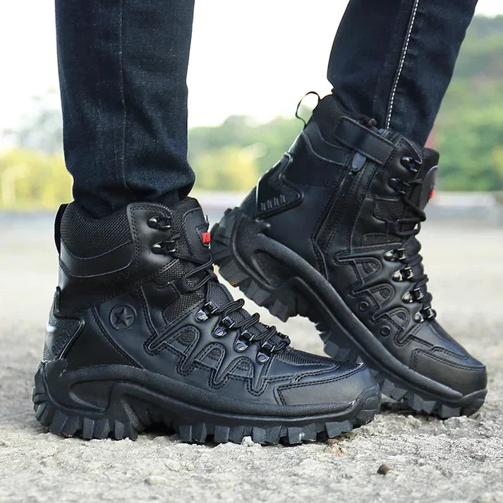 Schwarze Outdoor-Wanderschuhe mit robustem Profil, getragen von einer Person auf einem steinigen Weg. Ideal für Trekking und Abenteuer.