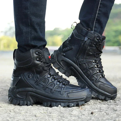 Schwarze Outdoor-Wanderschuhe mit robustem Profil, getragen von einer Person auf einem steinigen Weg. Ideal für Trekking und Abenteuer.