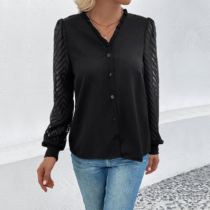Frau trägt schwarze Bluse mit Spitzenärmeln und blaue Jeans, steht vor weißem Hintergrund. Modetrend, elegante Damenbekleidung, Freizeitlook.
