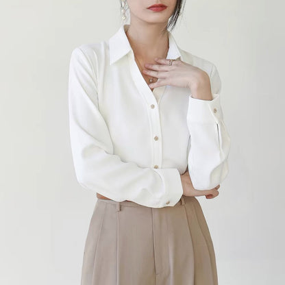 Frau in eleganter weißer Bluse und beigen Hose, minimalistisch, modisch, Business-Look, stilvolle Damenbekleidung, Büro-Outfit, Modefotografie.