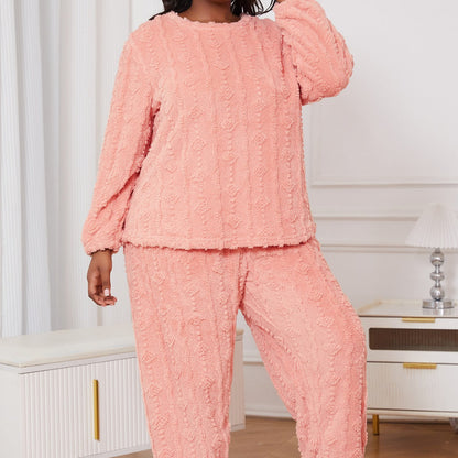 Frau in rosa Fleece-Pyjama-Set, gemütlich und modisch, steht in modernem Wohnzimmer. Bequeme Nachtwäsche für Damen, ideal für kühle Nächte.