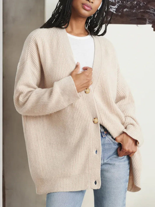 Beiger Strick-Cardigan mit Knöpfen, lässig über weißem T-Shirt und blauer Jeans getragen. Modetrend, Damenmode, Herbstoutfit.