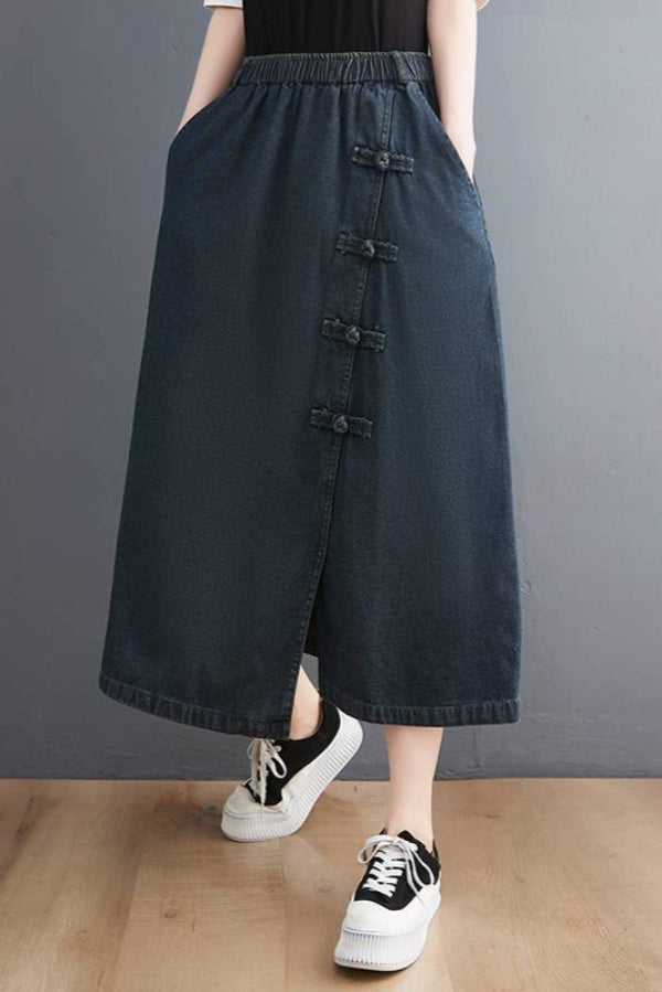 Damen-Jeansrock in Dunkelblau, knöchellang mit seitlichen Knöpfen, kombiniert mit weißen Sneakers. Modischer Freizeitlook für Frauen.