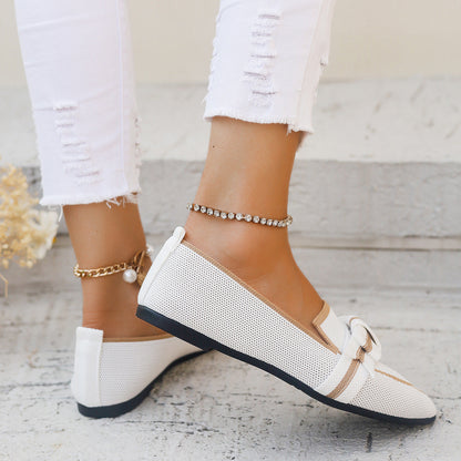 Weiße Damen-Loafer mit Schleife, getragen zu zerrissenen weißen Jeans. Elegante Sommermode, flache Schuhe, stilvoller Look für Frauen.