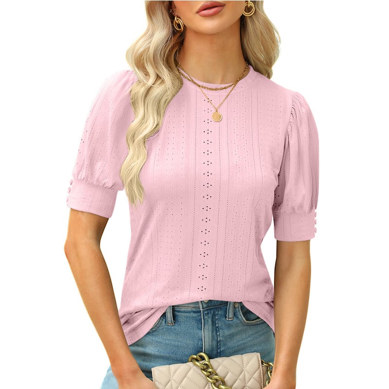 Frau in rosa Spitzenbluse mit kurzen Ärmeln, blonden Haaren und goldener Halskette, trägt eine beige gesteppte Handtasche. Modetrend, Damenmode.
