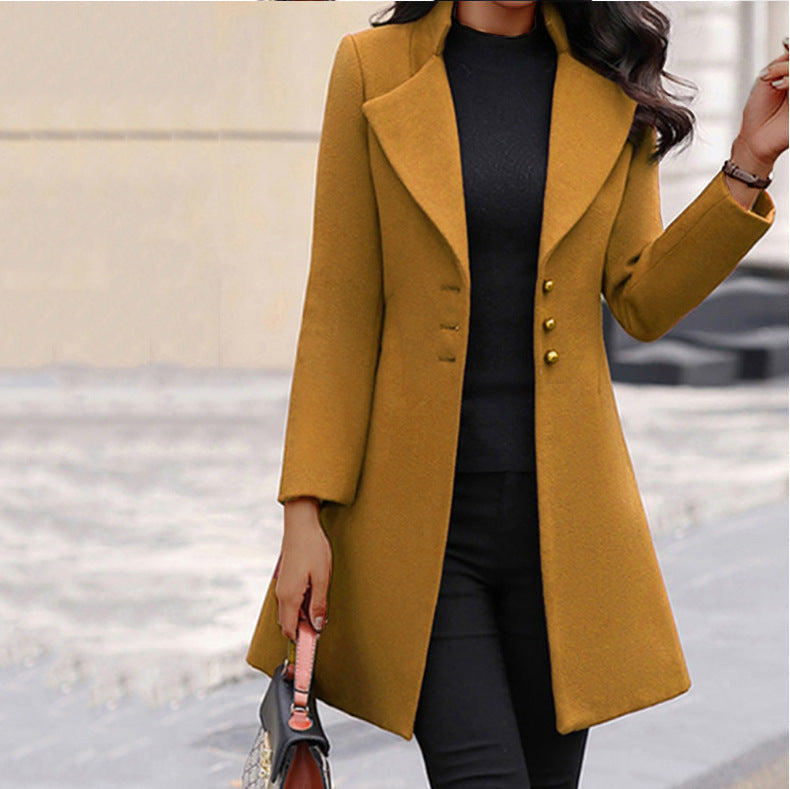 Frau in elegantem senfgelben Mantel mit Knöpfen, schwarzem Pullover und Hose. Herbstmode, stilvoller Look, Damenbekleidung, Straßenmode.