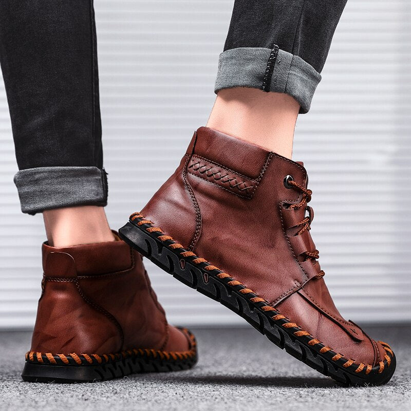 Braune Herren-Lederstiefel mit schwarzer Sohle, seitlich fotografiert. Modische, bequeme Schuhe für Herbst und Winter.