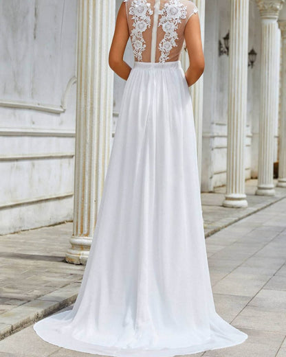 Brautkleid mit Spitze und transparentem Rücken, bodenlang, vor weißen Säulen. Elegantes Hochzeitskleid, romantisches Design, klassische Architektur.