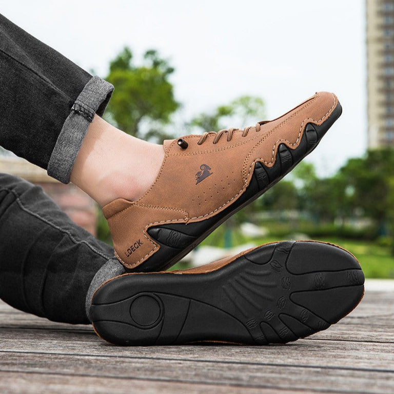 Braune Herren-Freizeitschuhe aus Leder mit schwarzer Sohle, getragen von einer Person auf Holzterrasse. Bequeme, stilvolle Herrenschuhe für den Alltag.