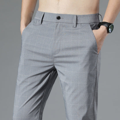 Graue karierte Herrenhose, moderne Passform, mit schwarzem Knopf und Taschen, getragen von einem Mann mit schwarzer Armbanduhr.