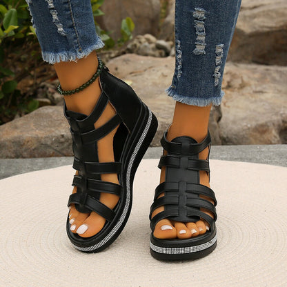 Schwarze Sandalen mit Riemchen und Glitzerdetails, getragen zu zerrissenen Jeans. Modische Damen-Sommerschuhe, ideal für Freizeit und Outdoor.