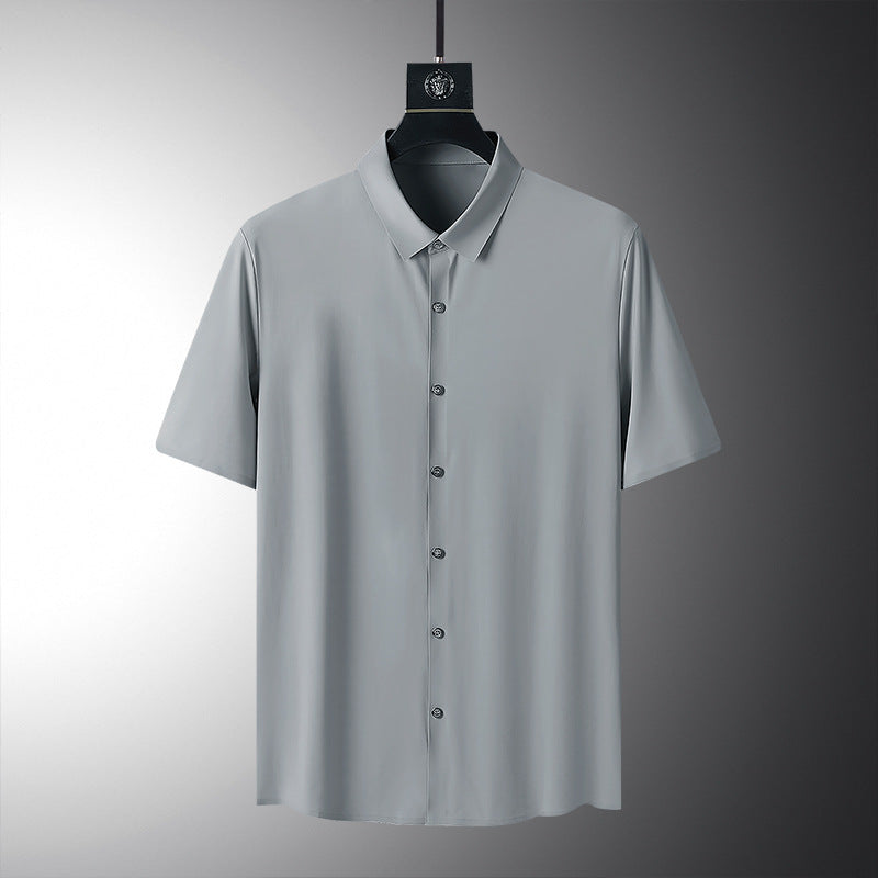 Graues Herrenhemd mit kurzen Ärmeln, Knopfleiste und klassischem Kragen, auf einem Kleiderbügel vor grauem Hintergrund. Elegante Herrenmode.