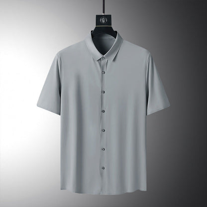 Graues Herrenhemd mit kurzen Ärmeln, Knopfleiste und klassischem Kragen, auf einem Kleiderbügel vor grauem Hintergrund. Elegante Herrenmode.
