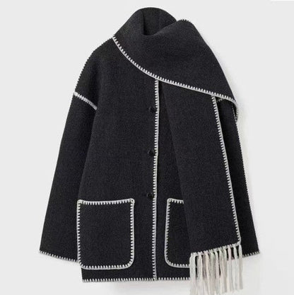 Dunkelgrauer Wollmantel mit weißen Ziernähten und passendem Schal, elegante Damenmode, Herbst-Winter-Kollektion, stilvoll und warm.