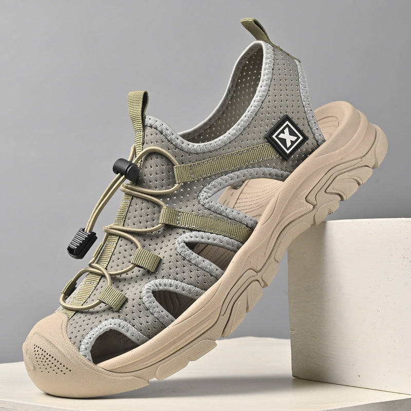 Grauer Outdoor-Sportsandale mit robustem Profil, atmungsaktivem Mesh-Obermaterial und verstellbarem Schnellverschluss. Ideal für Wandern und Trekking.