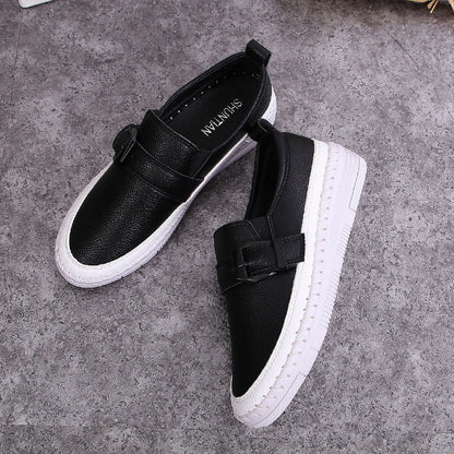 Schwarze Lederschuhe mit weißer Sohle auf grauem Hintergrund, modische Slipper für Damen, elegantes Design, bequeme Freizeitschuhe.