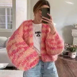 Frau im rosa-weiß gestreiften Strickpullover macht Selfie im Spiegel. Modetrend, gemütlicher Look, Oversize-Pullover, Innenraum.