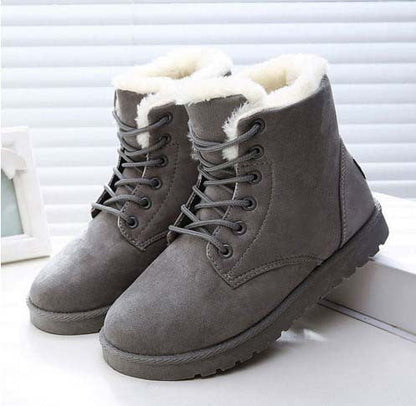 Graue Winterstiefel mit weißem Kunstfellfutter, robustem Design und Schnürung, ideal für kaltes Wetter. Perfekt für Damenmode und Outdoor-Aktivitäten.