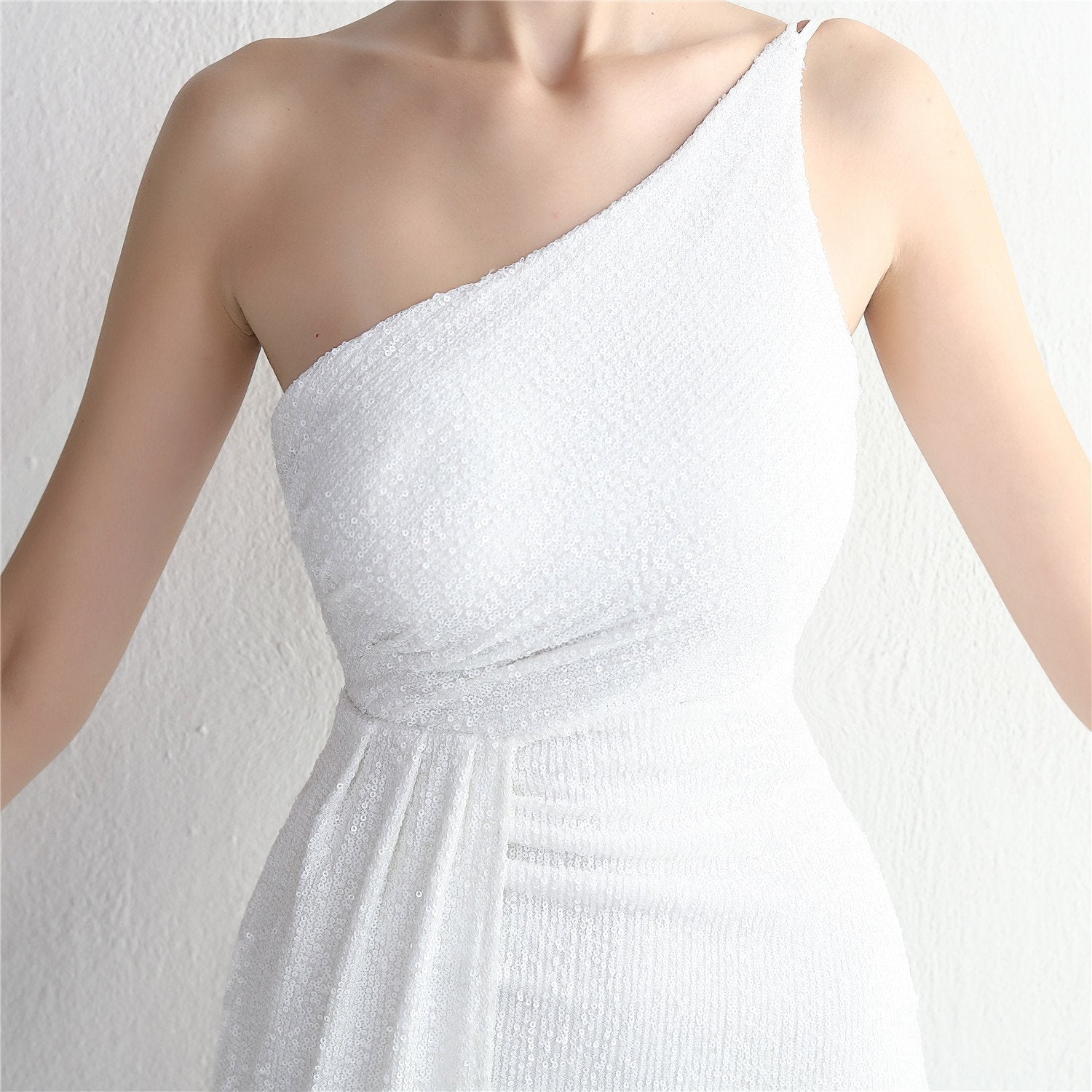 Ein elegantes, weißes, schulterfreies Abendkleid mit asymmetrischem Schnitt und feiner Textur, ideal für formelle Anlässe und Hochzeiten.