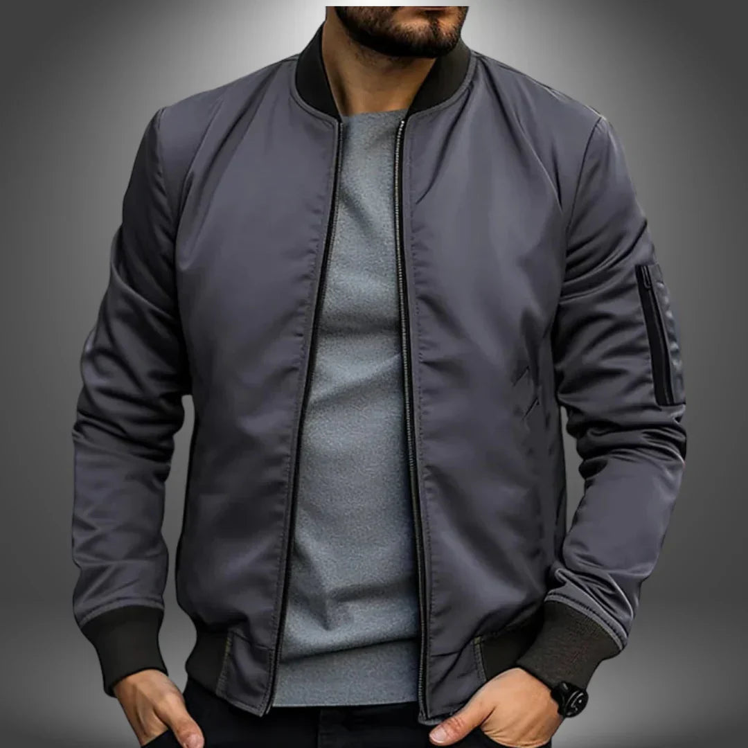 Graue Bomberjacke für Herren, modern und stilvoll, mit Reißverschlusstasche am Ärmel. Perfekt für Freizeitmode und urbane Outfits.