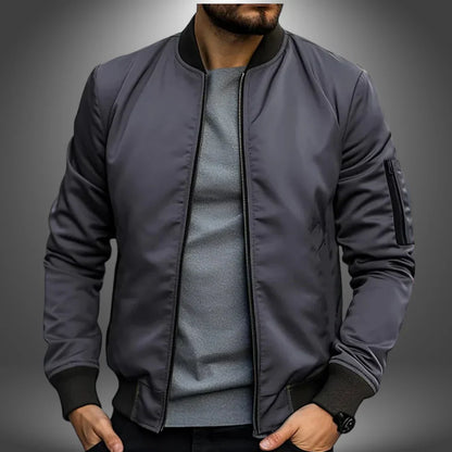 Graue Bomberjacke für Herren, modern und stilvoll, mit Reißverschlusstasche am Ärmel. Perfekt für Freizeitmode und urbane Outfits.